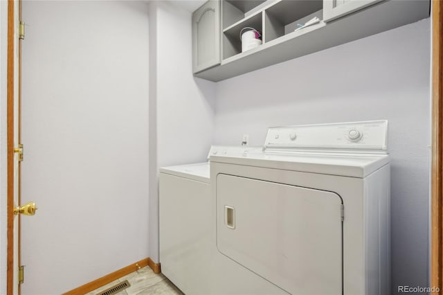 laundry area with light tile patterned floors and washer and dryer