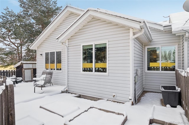 view of snow covered rear of property