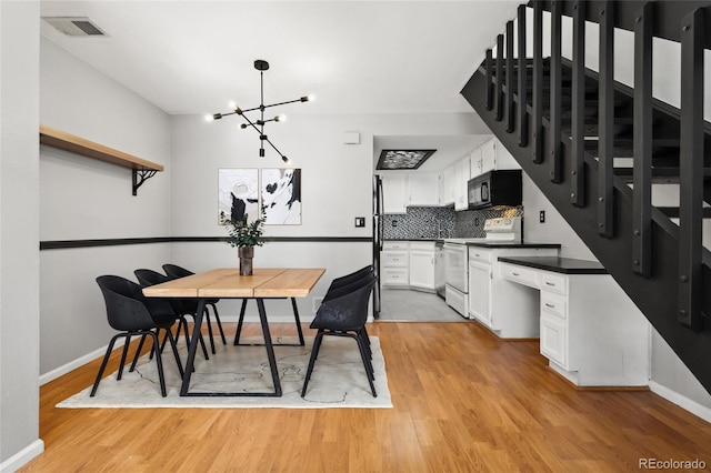 1885 S Quebec Way Unit A28, Denver, CO 80231 - dining room featuring a chandelier, baseboards, and light wood-type flooring