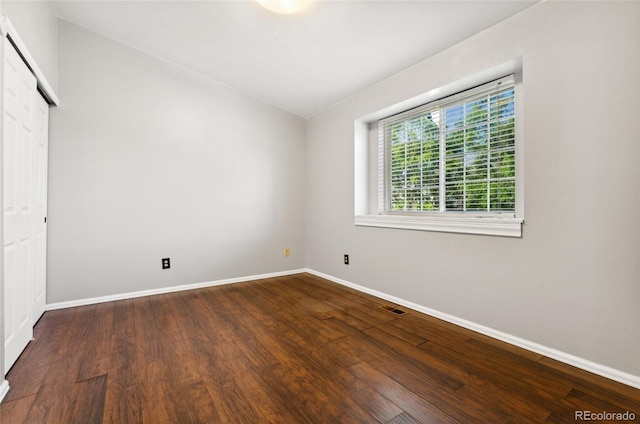 1885 S Quebec Way Unit A28, Denver, CO 80231 - unfurnished bedroom with baseboards, wood finished floors, and a closet