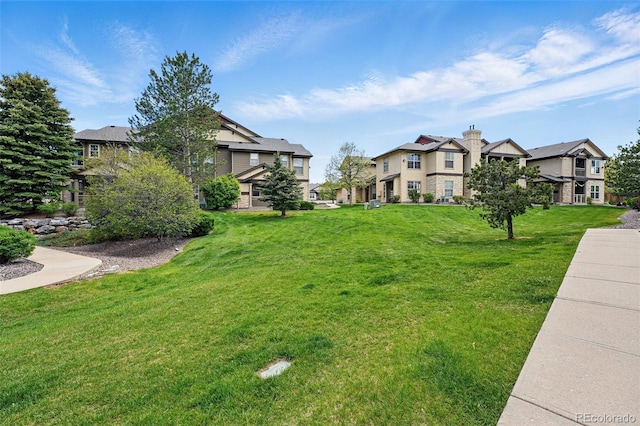 view of property's community featuring a residential view and a yard