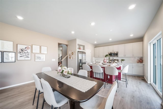 3879 N Shawnee St, Aurora, CO 80019 - dining space featuring light wood-style floors, recessed lighting, baseboards, and stairs