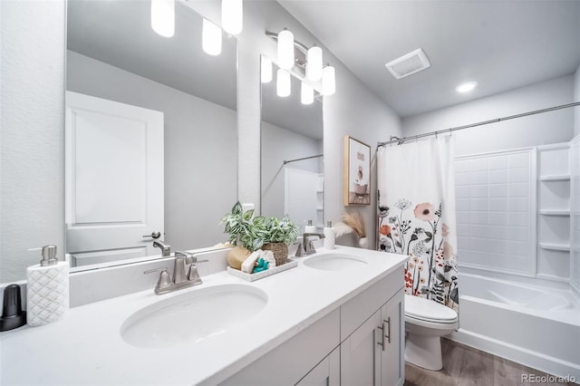3879 N Shawnee St, Aurora, CO 80019 - full bathroom with double vanity, toilet, wood finished floors, and shower / bath combo