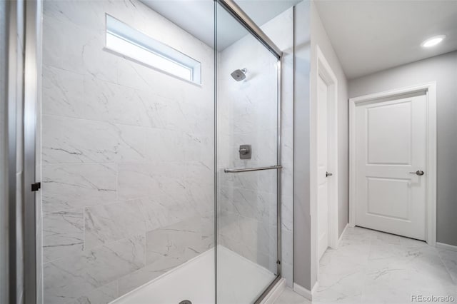 3879 N Shawnee St, Aurora, CO 80019 - bathroom featuring a stall shower, marble finish flooring, and baseboards