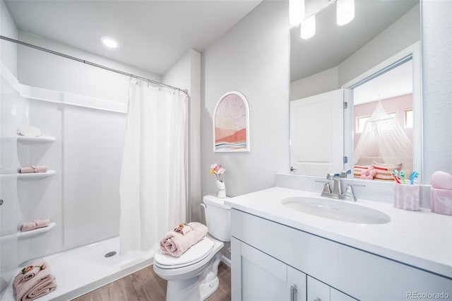 3879 N Shawnee St, Aurora, CO 80019 - full bathroom featuring wood finished floors, toilet, vanity, and a shower with shower curtain