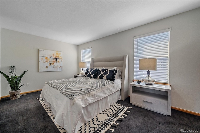 bedroom with dark colored carpet and a textured ceiling