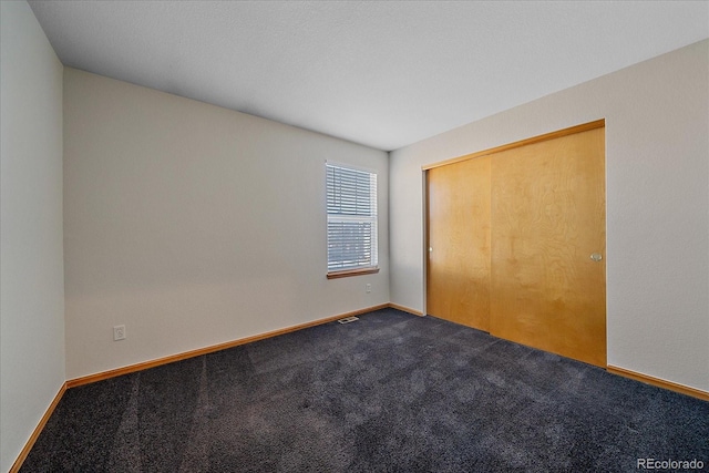 unfurnished bedroom featuring carpet flooring and a closet