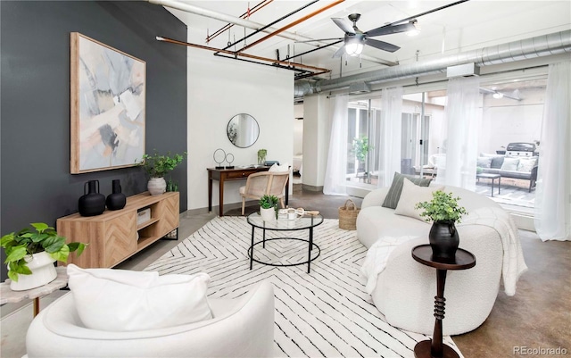 living room featuring finished concrete flooring and a ceiling fan