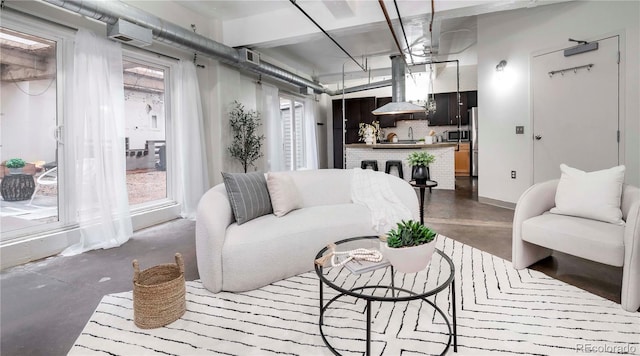 living area featuring baseboards and finished concrete floors