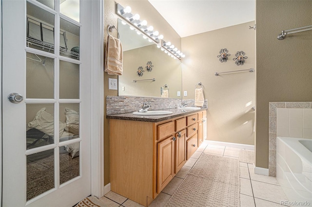 bathroom with tile patterned flooring, vanity, and a tub