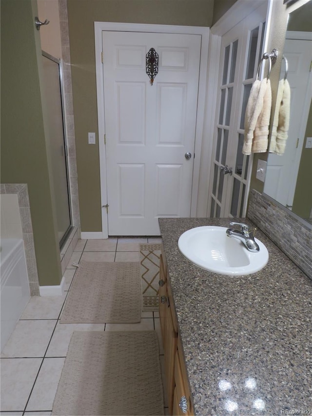 bathroom with tile patterned flooring, vanity, and plus walk in shower