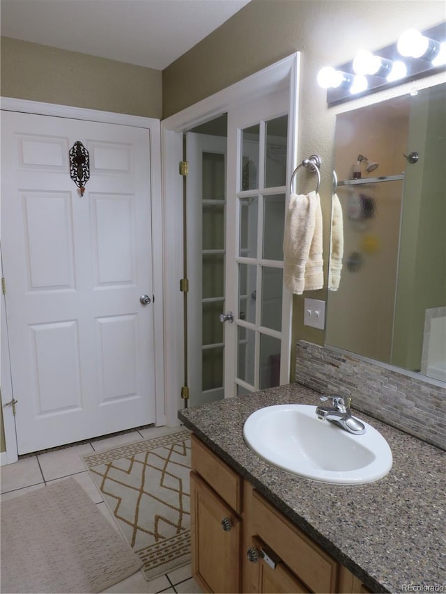 bathroom with tile patterned flooring, vanity, and a shower with shower door