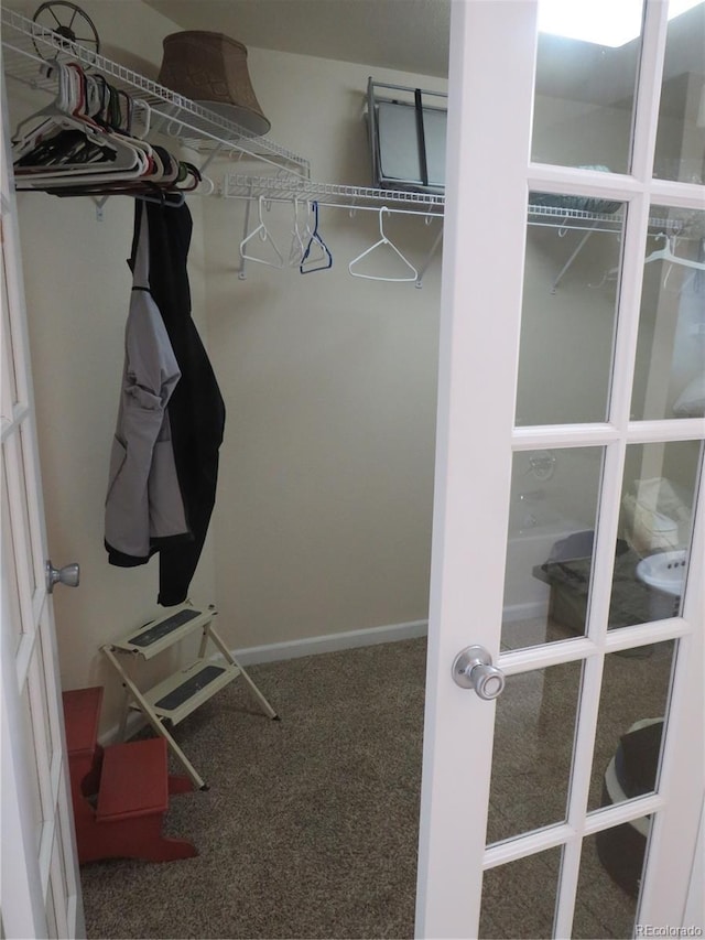 walk in closet featuring carpet flooring