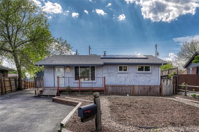 7541 Julian St, Westminster, CO 80030 - back of house featuring roof mounted solar panels, a porch, brick siding, and roof with shingles