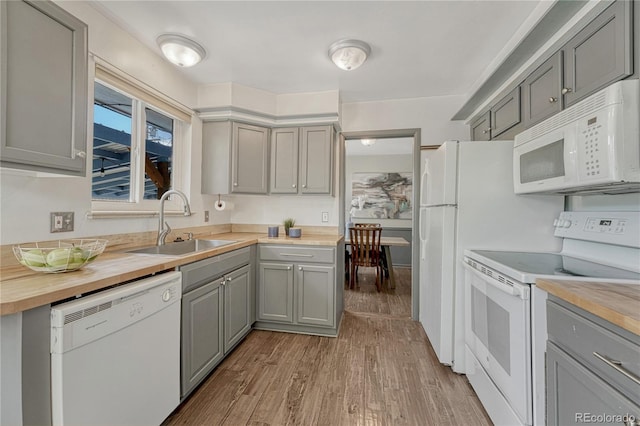 7541 Julian St, Westminster, CO 80030 - kitchen with white appliances, gray cabinets, a sink, butcher block countertops, and light wood-style flooring