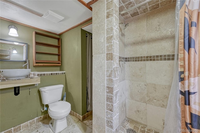 7541 Julian St, Westminster, CO 80030 - bathroom featuring a tile shower, toilet, a sink, and crown molding