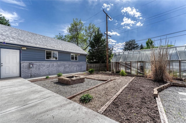 7541 Julian St, Westminster, CO 80030 - view of yard featuring an exterior structure, a vegetable garden, fence, and an outbuilding