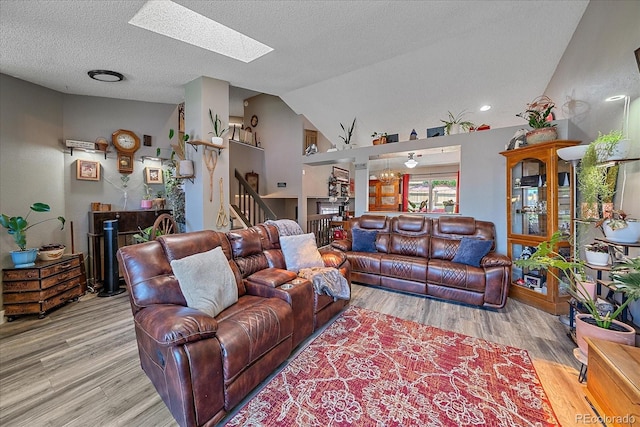 6085 S Parfet St, Littleton, CO 80127 - living room featuring a skylight, stairs, wood finished floors, lofted ceiling, and a textured ceiling
