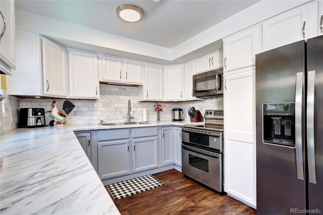4856 E Hinsdale Pl, Centennial, CO 80122 - kitchen featuring appliances with stainless steel finishes, light stone countertops, backsplash, and white cabinets