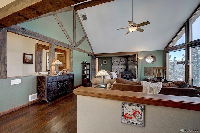 living room featuring dark wood-type flooring, ceiling fan, vaulted ceiling, and a wood stove