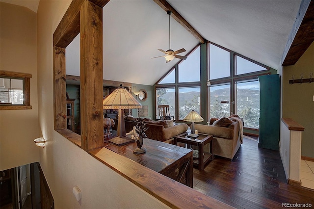 living room featuring ceiling fan, dark hardwood / wood-style floors, a mountain view, and lofted ceiling with beams