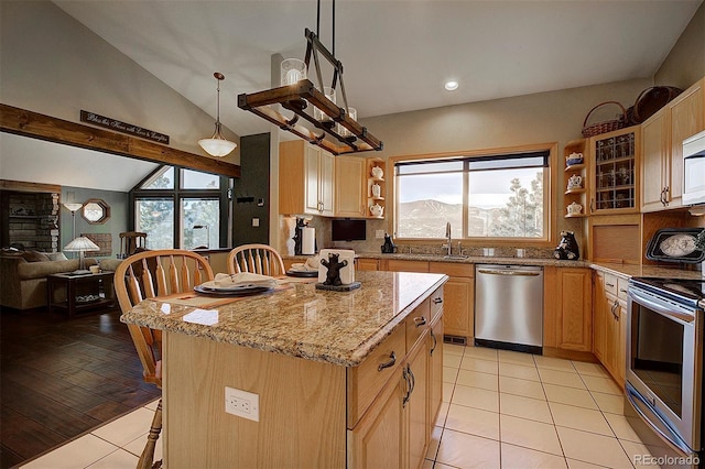 kitchen featuring stainless steel appliances, a center island, light tile patterned flooring, decorative light fixtures, and vaulted ceiling