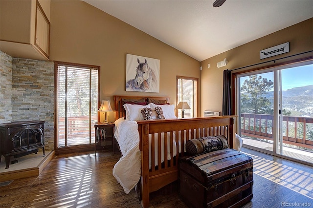 bedroom featuring vaulted ceiling, a wood stove, dark hardwood / wood-style flooring, access to outside, and a mountain view