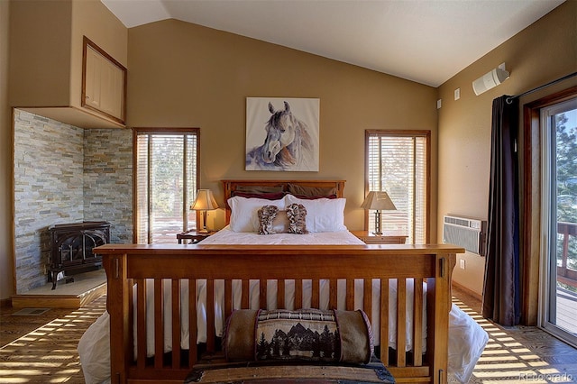 bedroom featuring multiple windows, vaulted ceiling, a wood stove, and cooling unit