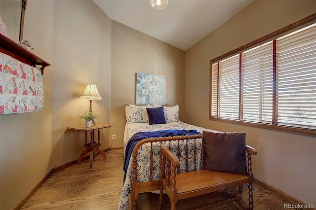 bedroom featuring hardwood / wood-style flooring and vaulted ceiling