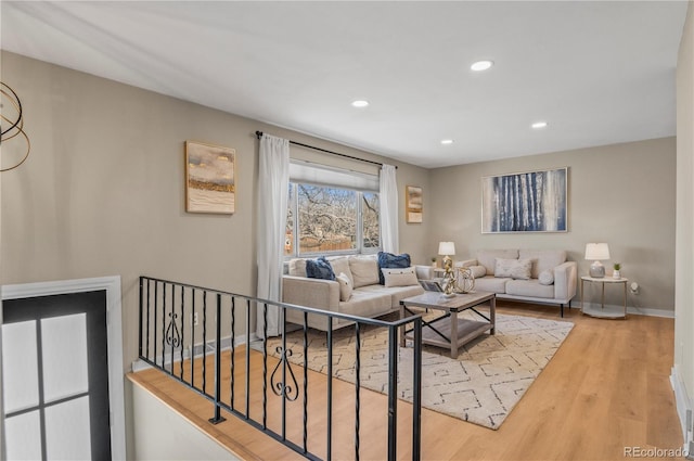 living room featuring baseboards, recessed lighting, and wood finished floors