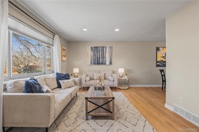 living room featuring recessed lighting, visible vents, baseboards, and light wood-style flooring