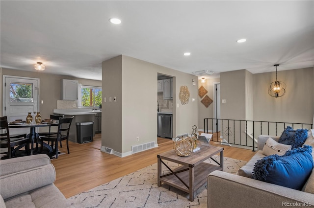 living room with light wood-style floors, baseboards, visible vents, and recessed lighting