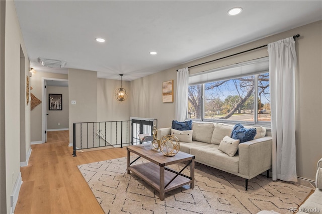 living room featuring visible vents, baseboards, recessed lighting, and light wood-style floors