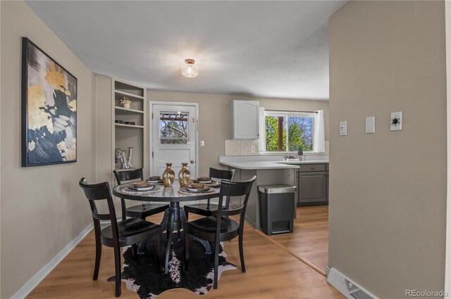 dining room featuring visible vents, light wood-type flooring, and baseboards