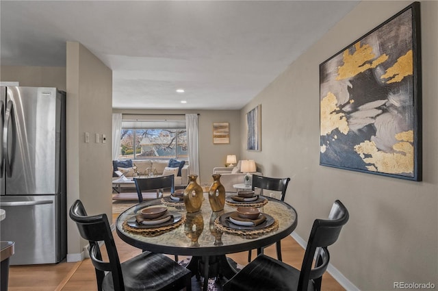 dining space featuring baseboards and wood finished floors
