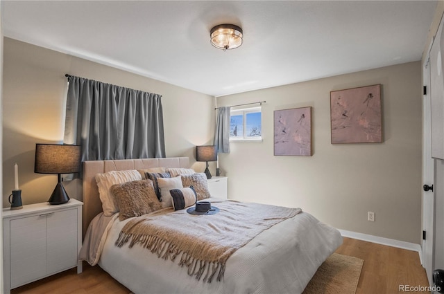 bedroom with baseboards and wood finished floors