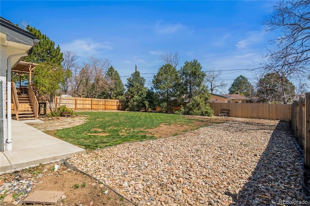 view of yard featuring a patio area, stairway, and a fenced backyard