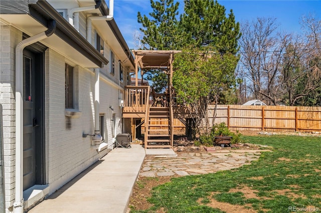view of yard with a patio area, fence, a deck, and stairway