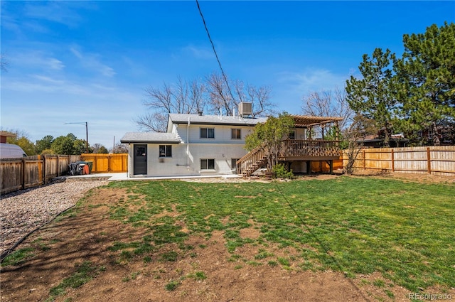 back of house with a yard, a fenced backyard, and stairway