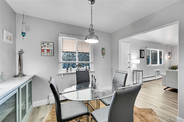 dining room with a healthy amount of sunlight, a wall mounted AC, light hardwood / wood-style flooring, and a baseboard heating unit