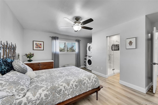 bedroom with light hardwood / wood-style floors, stacked washing maching and dryer, ensuite bathroom, and ceiling fan