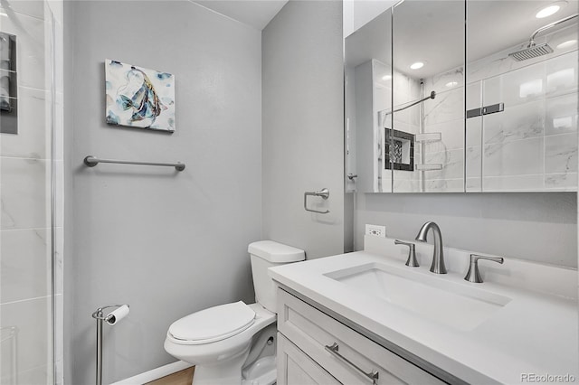 bathroom with a shower with door, vanity, and toilet