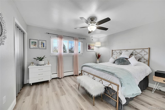 bedroom featuring a closet, ceiling fan, light hardwood / wood-style flooring, and a baseboard heating unit