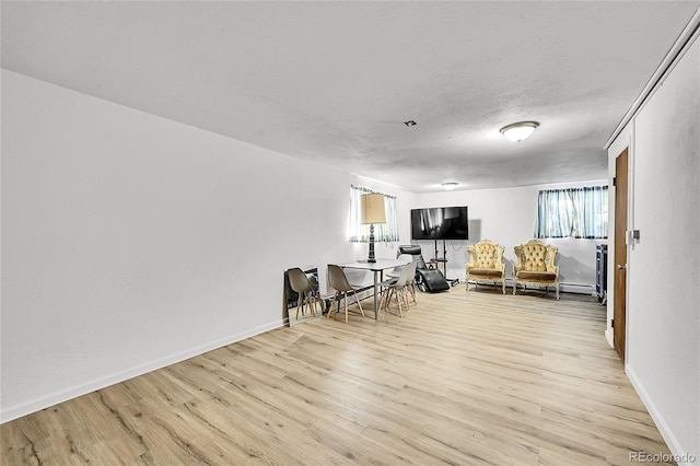 living room featuring a healthy amount of sunlight, a textured ceiling, and light wood-type flooring