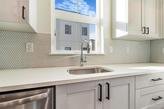 kitchen featuring dishwasher, tasteful backsplash, and sink