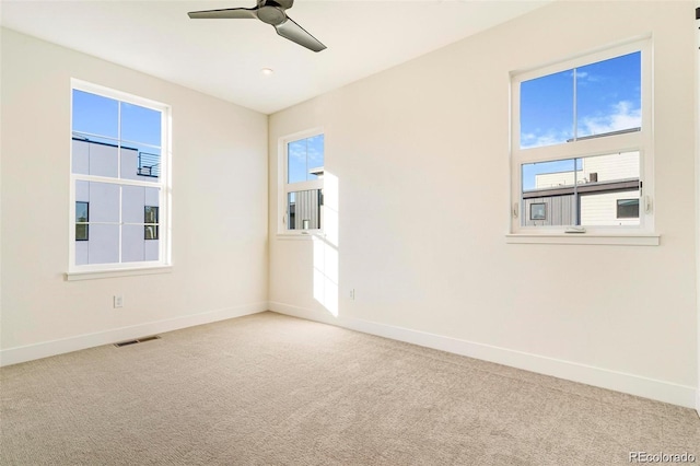 spare room with carpet flooring, plenty of natural light, and ceiling fan