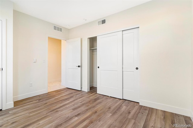 unfurnished bedroom featuring a closet and light hardwood / wood-style flooring