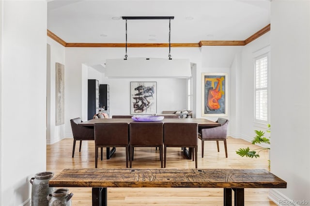 dining room with hardwood / wood-style flooring and crown molding