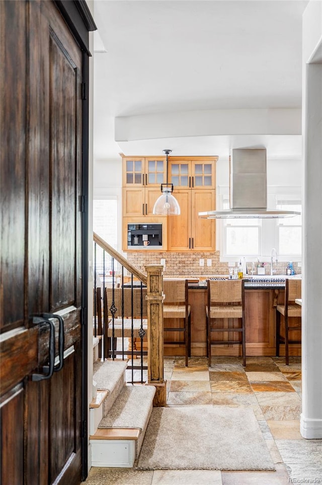 kitchen with black oven, sink, decorative backsplash, and exhaust hood