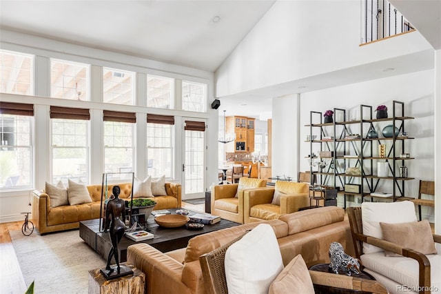 living room with high vaulted ceiling and light wood-type flooring